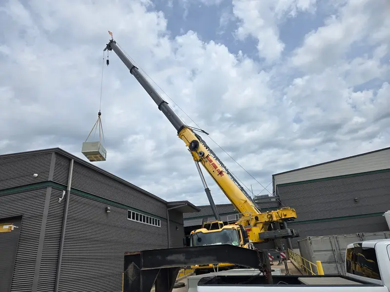 Crane lifting a unit to a roof